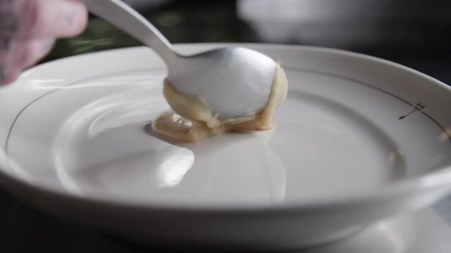 Close up, chef drizzles sauce on plate