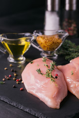 Raw chicken fillets with spices and herbs.
