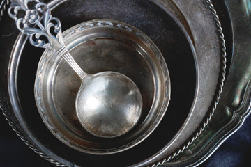 Vintage silver cutlery on dark stone background. Old kitchen utensils