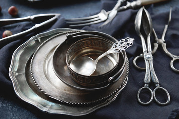 Vintage silver cutlery on dark stone background. Old kitchen utensils