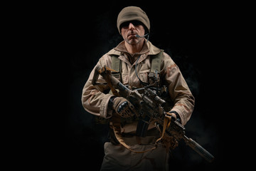 Obraz premium special forces soldier of the united states poses with a rifle on a black background