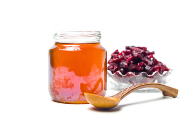 Jar of honey and dried cranberry isolated on white background