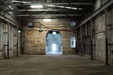 Foto op Plexiglas Binnenkant van oude verlaten fabriek. Een structuurinterieur van een leeg industriemagazijn. Een verlaten oude fabriek zonder apparatuur en machine. Afbeelding van rustieke fabrieksruimtestructuur gemaakt van ijzer en staal. © suthichai