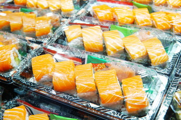 Selective focus on salmon sushi box. Salmon sushi in takeaway box ready for sale in restaurant. Sushi box with wasabi and ginger for hurry meal. Salmon sushi box cook in asian style