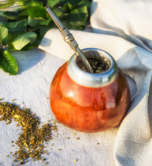Yerba mate in calabash with bombilla under sun beam