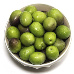 Green olives ready to eat in white background.