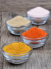 Spices in a transparent bowls on wooden table