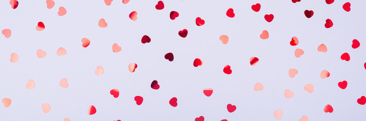 Grey background with red glitter heart confetti. Valentine day concept. Trendy minimalistic flat...