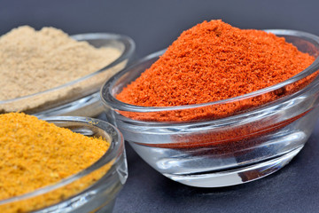 Bowls with spices on black background