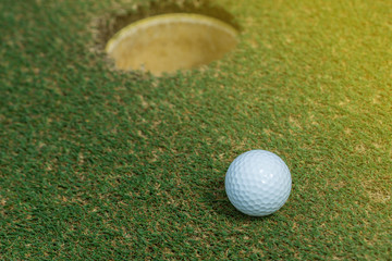Golf ball on green near golf hole Concept of success, win	