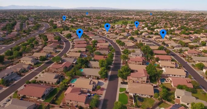 An aerial establishing shot of a typical Arizona residential neighborhood with GPS markers over random homes. Phoenix suburbs.  	