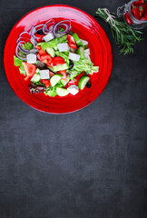 Greek salad feta, cherry tomatoes, olives, cucumbers on a dark background. Top view. Food background