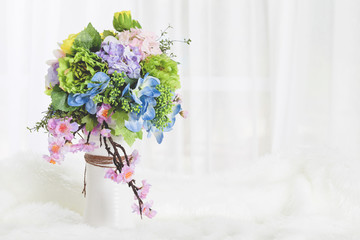 Bouquet of flowers and greenery is on the white table