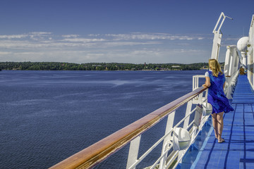 Fototapeta na wymiar Lone woman views islands from a cruise ship in archipelago, off Stockholm , Sweden