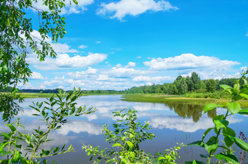 Colorful summer landscape with lake and sky with clouds
