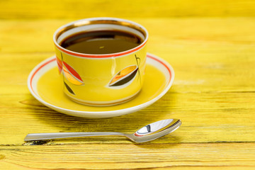 tea in a yellow mug on a wooden background