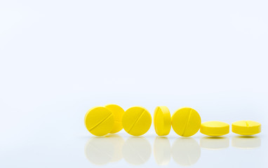 Yellow tablets pills isolated on white background with copy space. Pile of medicine.