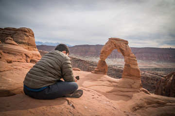 Arches national park boy with smartphone delicate arch