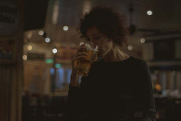 Woman having a beer at a bar