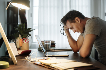 Man stressed while working on laptop - Powered by Adobe