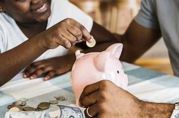 Dad and daughter saving money to piggy bank - obrazy, fototapety, plakaty
