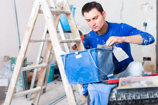 Young builder handyman choosing tool in toolbox