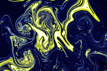Swirling paint oil abstracts of water and acrylic paint creating a hazardous pollution theme for environment and nature themes and ideas. Globes release into the yellow black liquid