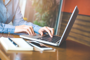 Business woman hand working with a laptop computer in the office.