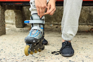 Woman putting on roller skates outdoor.