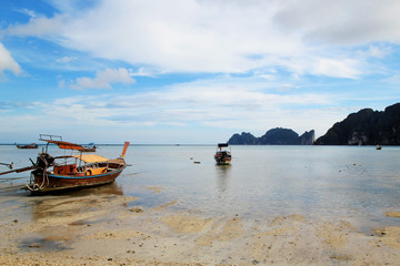 Obraz premium The view on the long boats on a coast of sea on a low tide. Island Phi Phi, Thailand.