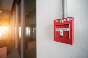 Red fire alarm mounted on the crack wall