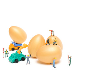 Miniature people work at Easter-eggs for Easter day