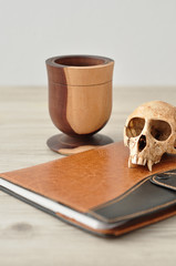 A vervet monkey skull with a book and a wooden mug