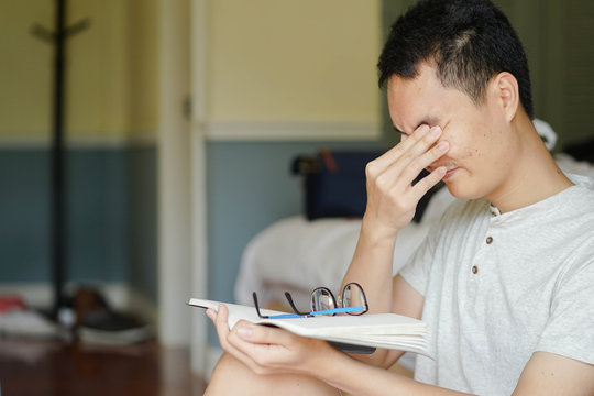 Close Up Asian Man Take Care Eyes And Resting  After Hard Reading Book , Eyes Care Concept