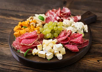 Peel and stick wall murals Starter Antipasto catering platter with bacon, jerky, sausage, blue cheese and grapes on a wooden background.