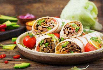 Burritos wraps with beef and vegetables on a wooden background. Beef burrito , mexican food. Healthy food background. Mexican cuisine.