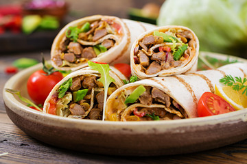 Burritos wraps with beef and vegetables on a wooden background. Beef burrito , mexican food. Healthy food background. Mexican cuisine.