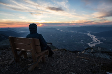 Adventurous man on top of the mountain during a vibrant sunset. Taken on Cheam Peak, near Chilliwack, East of Vancouver, British Columbia, Canada.