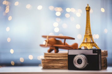 camera with Eiffel tower and airplane with books