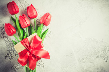 Spring bouquet of red tulips and gift box.