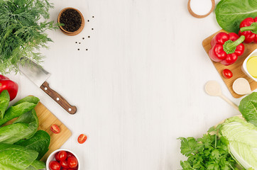 Healthy vegetarian ingredients for spring fresh green salad and kitchenware on white wood board,...