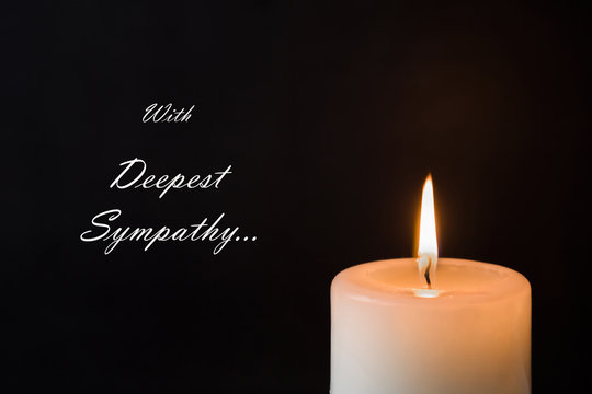 Condolence card with text. Candle with flame on the dark background. Sorrow concept.