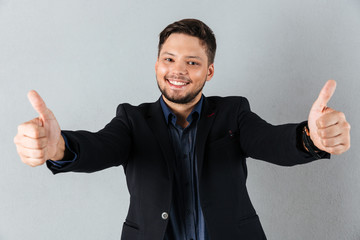 Portrait of a happy businessman showing two thumbs up