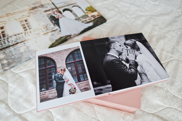 Fototapeta na wymiar Pages with wedding photos of a photobook or photo album on bed.