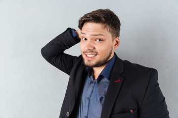 Portrait of a confused businessman skratching his head