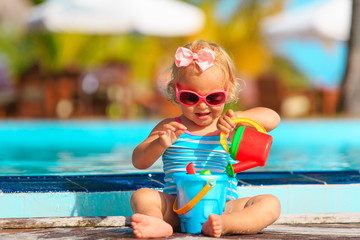 Obraz na płótnie Canvas cute little girl play with water on tropical beach