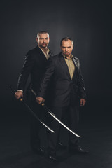 businessmen with katana swords isolated on black