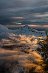 Dramatic Aerial view of a famous volcano that can be seen from Seattle and Vancouver, during a cloudy sunset. Located in Washington State, North America.
