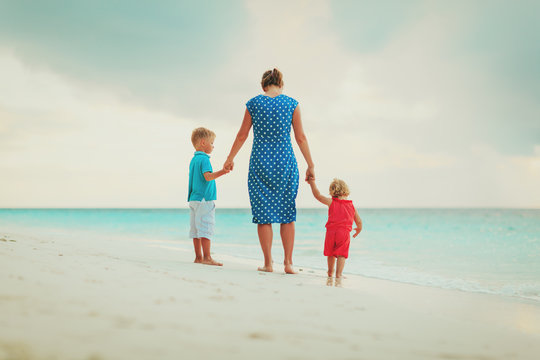 mother and two kids walking on beach
