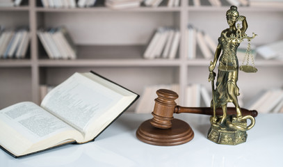 Law and Justice concept. Mallet of the judge, books, scales of justice. Gray stone background, reflections on the floor, place for typography. Courtroom theme.